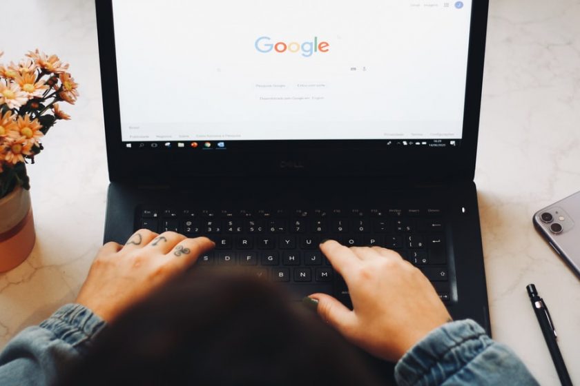 Person sitzt vor Laptop und nutzt Google