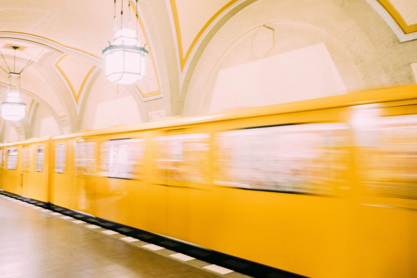 Eine gelbe U-Bahn in Berlin fährt durch den Bahnhof.
