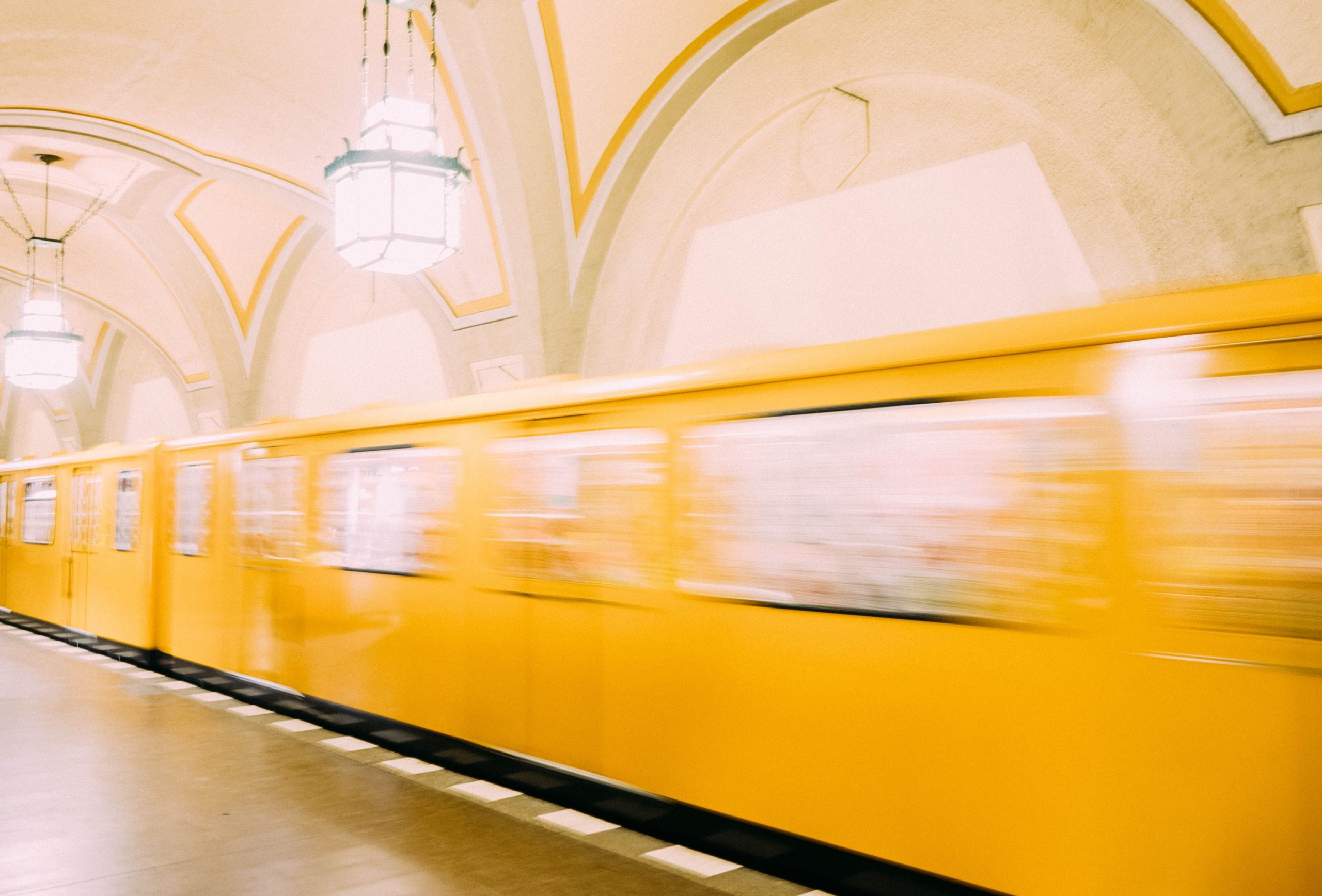 Eine gelbe U-Bahn in Berlin fährt durch den Bahnhof.