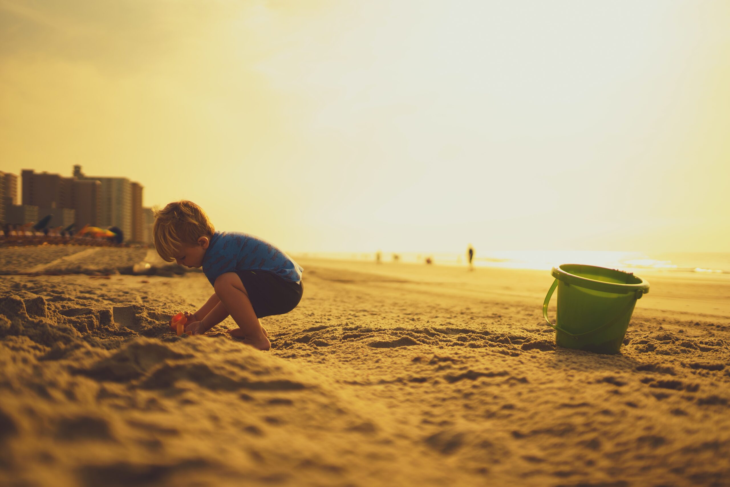 Kind spielt zum Sonnenuntergang am Strand
