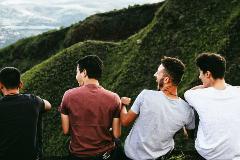 Vier Männer blicken auf grüne Berge