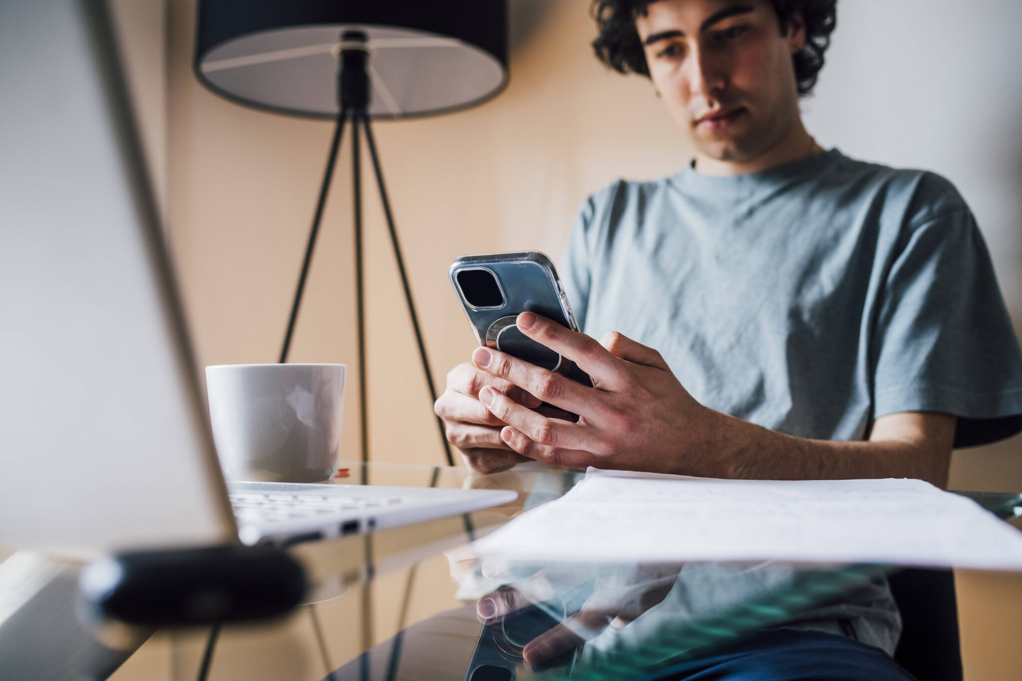 Mann sitzt an einem Tisch und benutzt sein Smartphone