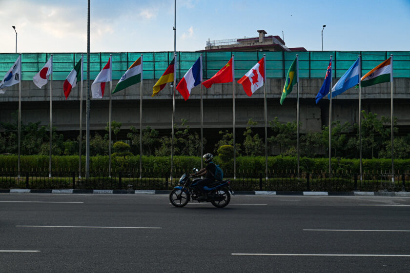 Ein Motorrad fährt an verschiedenen Länder Flaggen vorbei