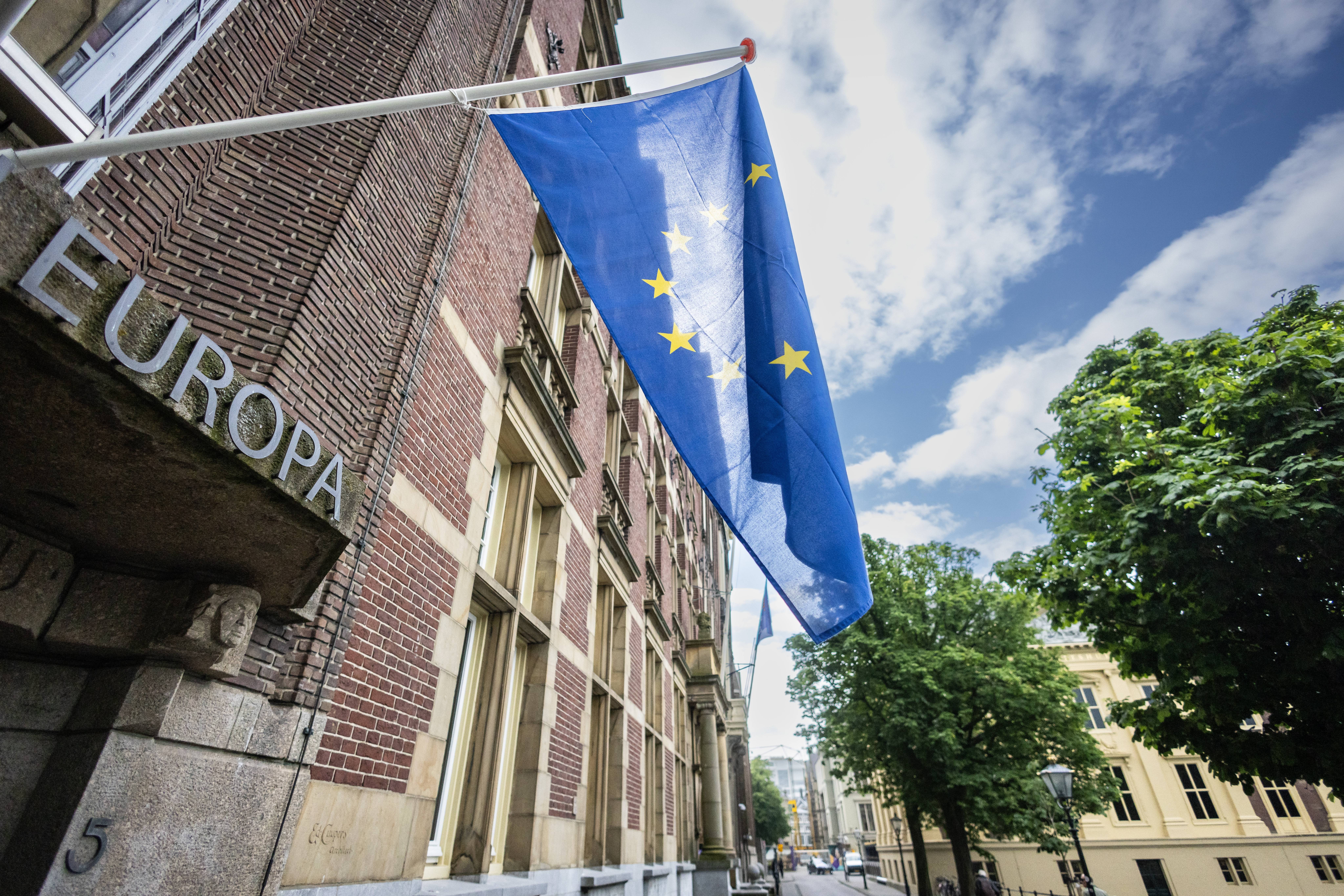 Ein Backsteingebäude auf dem EUROPA steht und vor dessen Eingang die Flagge der Europäischen Union gehisst ist