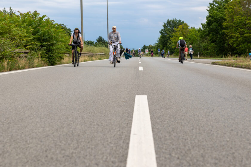 Radfahrer:innen auf einer Straße während einer Demo im Sommer