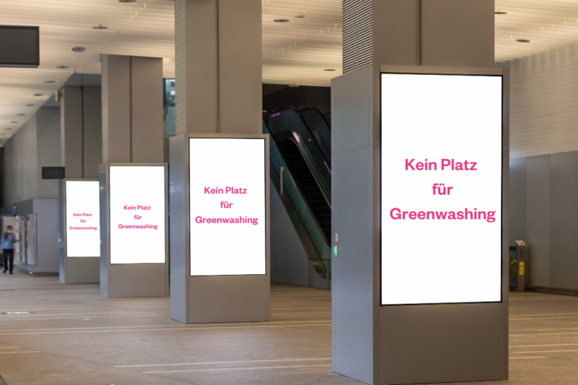 eine Reihe von digitalen Werbetafeln in einer U-Bahnstation, auf denen steht: Kein Platz für Greenwashing