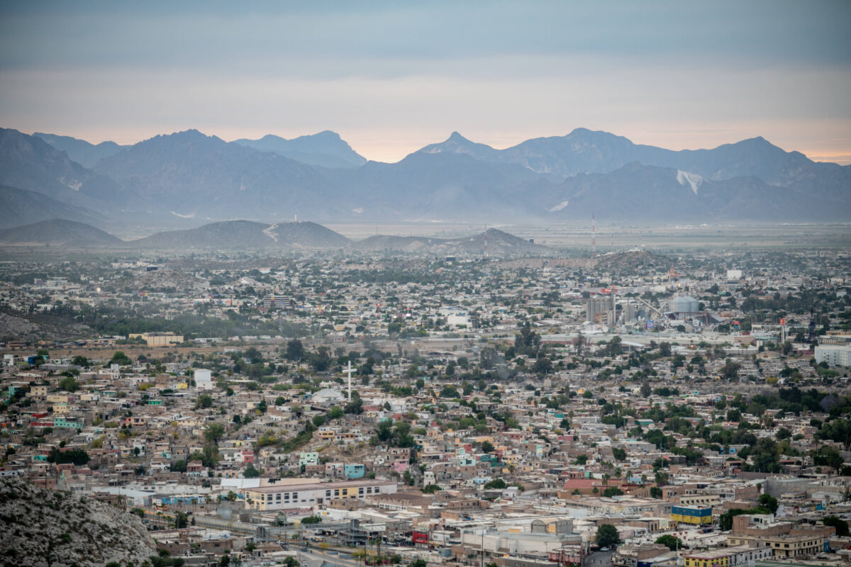 Eine Luftaufnahme der Stadt Torreon in Mexiko. Eine Großstadt, im Hintergrund sieht man hohe Berge.