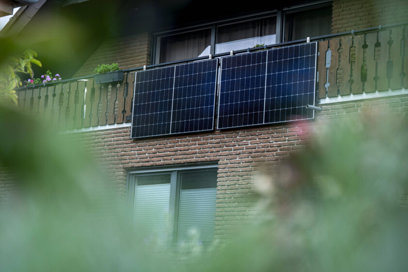 Ein Balkonkraftwerk erzeugt auf einem Balkon an einem Haus Strom