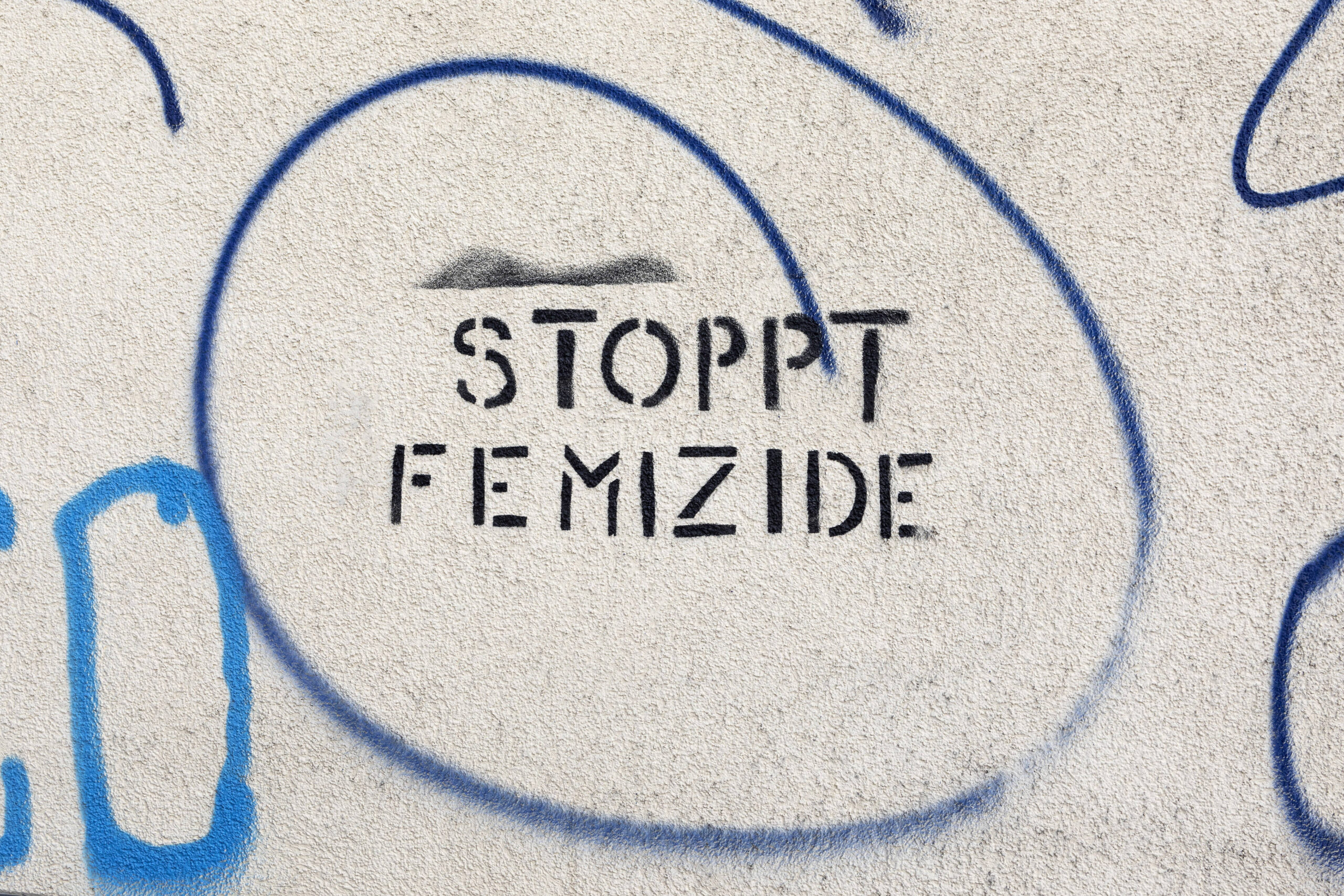 Wand mit Aufschrift Stoppt Femizide