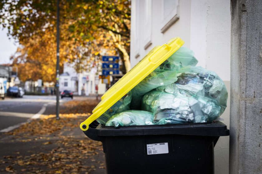 Verpackungsmüll Symbolbild überfüllte Mülltonne mit gelbem Deckel