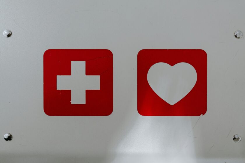 Herz- und Kreuz-Symbol an einer weißen Plakette