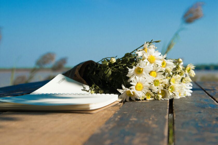 Auf einem Tisch liegen ein Brief und Blumen